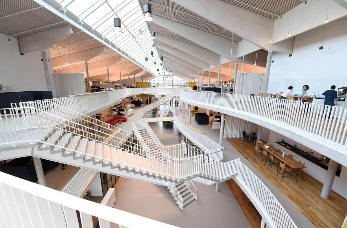Die Arbeitsflächen erstrecken sich beidseitig des mittigen Atriums und sind durch Stege und Treppen miteinander verbunden.