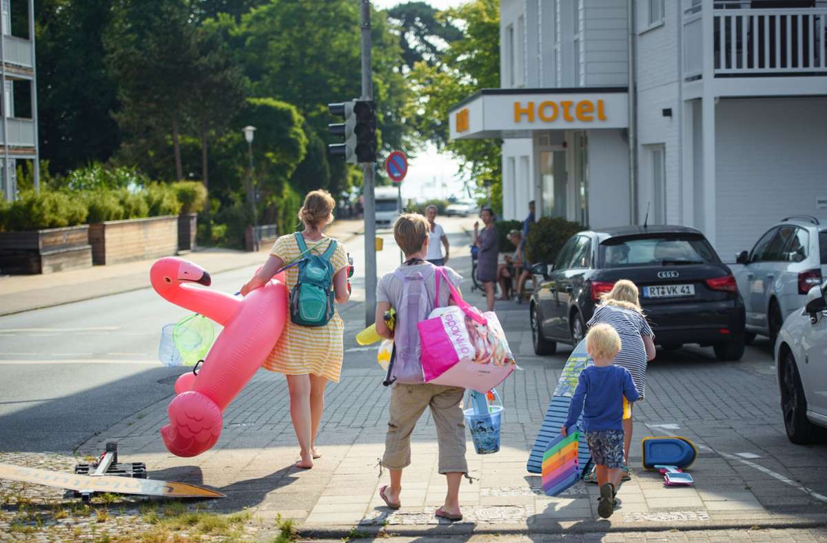 Mit Kühltaschen und Badetieren geht es in der Gemeinde Scharbeutz zum Strand.