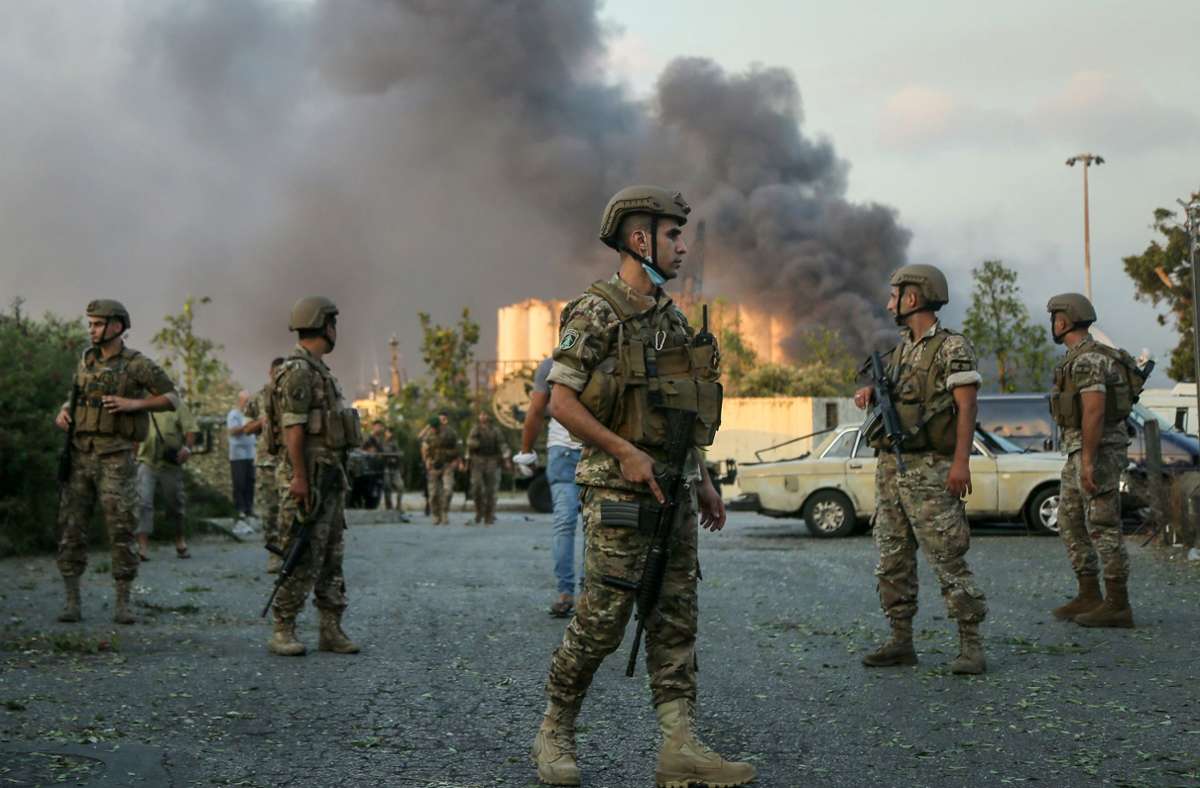 Soldaten stehen in der Nähe des Ortes einer Explosion am Hafen.