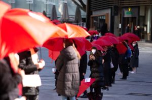 Protest gegen Femizide  unter blutroten Schirmen