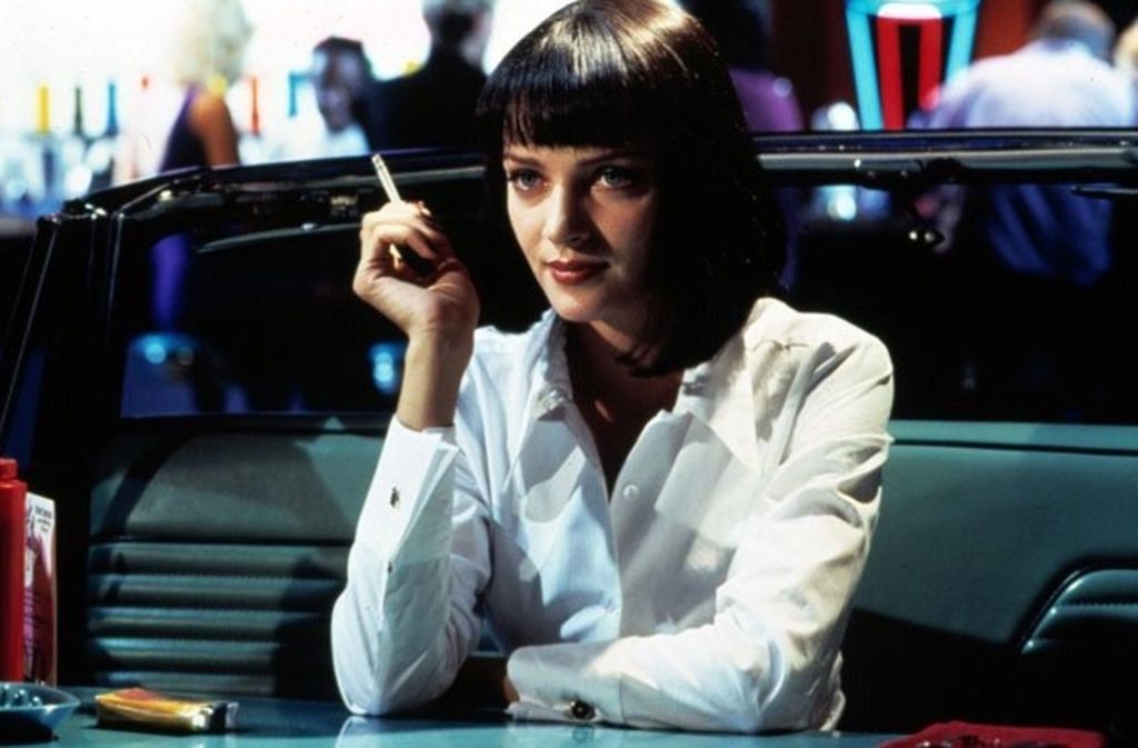 Die charakteristische weiße Bluse, schwarze Hose und die Zigarette in der Hand: Mia Wallace aus Quentin Tarantino’s „Pulp Fiction“ ist deutlich zu erkennen. Ein roter Lippenstift und eine passende Perücke runden das Outfit ab.