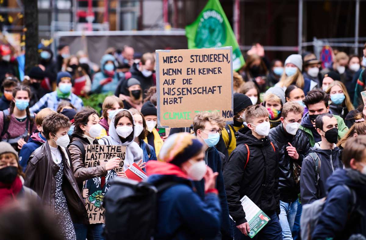 „Wieso studieren, wenn eh keiner auf die Wissenschaft hört“, steht auf einem Transparent, das ein Demonstrant in die Höhe hält. Foto: dpa/Annette Riedl