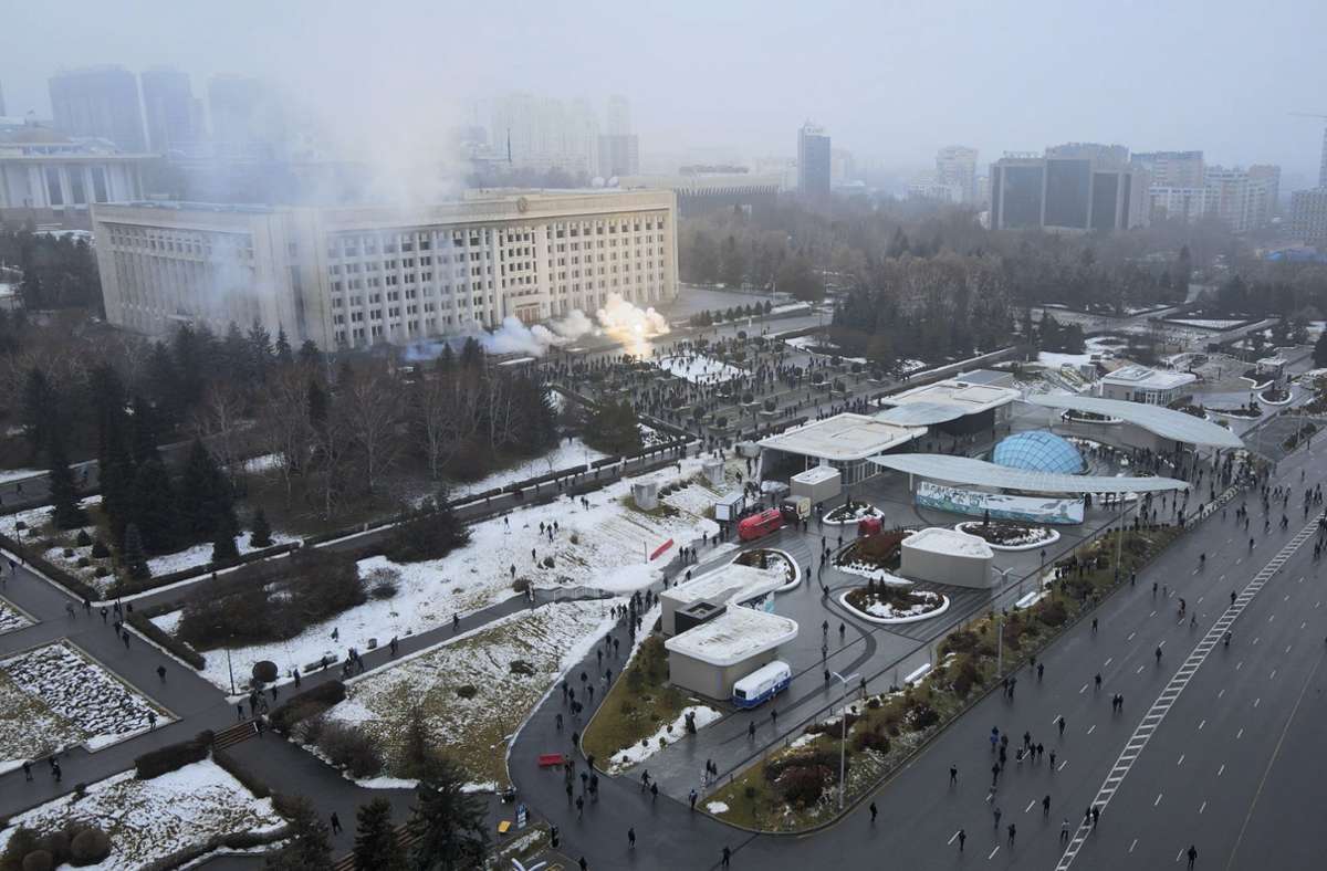 Rauch steigt vor dem Rathaus in Almaty auf, vor dem sich Demonstranten versammelt haben. Foto: dpa/Yan Blagov
