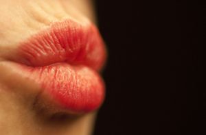 Frau beißt Mann beim Küssen die Lippe blutig