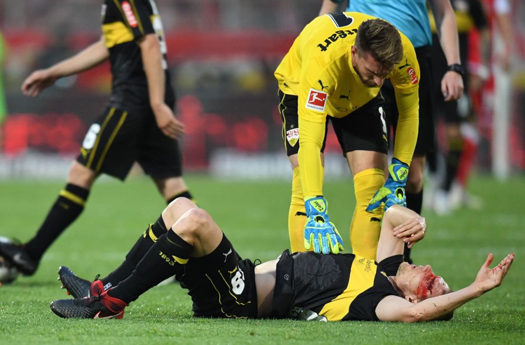 Schwer getroffen: der VfB-Profi Holger Badstuber liegt am Boden, nachdem er sich eine klaffende Wunde am Kopf zugezogen hat. Torhüter Ron-Robert Zieler kümmert sich um ihn. Foto: AFP
