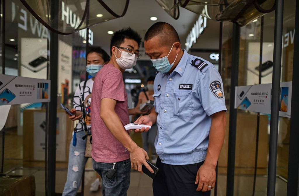 Wuhan, China: Ein Sicherheitsmann misst am Eingang eines Elektronikladens Fieber. Auch eine Gesundheitsapp, die das Risiko der Nutzer einstuft, sich infiziert zu haben, spielte im chinesischen Alltag in der letzten Zeit eine wichtige Rolle, zum Beispiel beim Einlass in Restaurants.