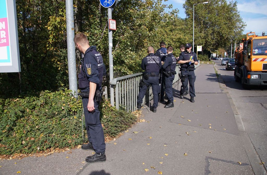 Polizisten durchsuchen das Gebiet rund um den Fundort einer Wasserleiche am Neckar.