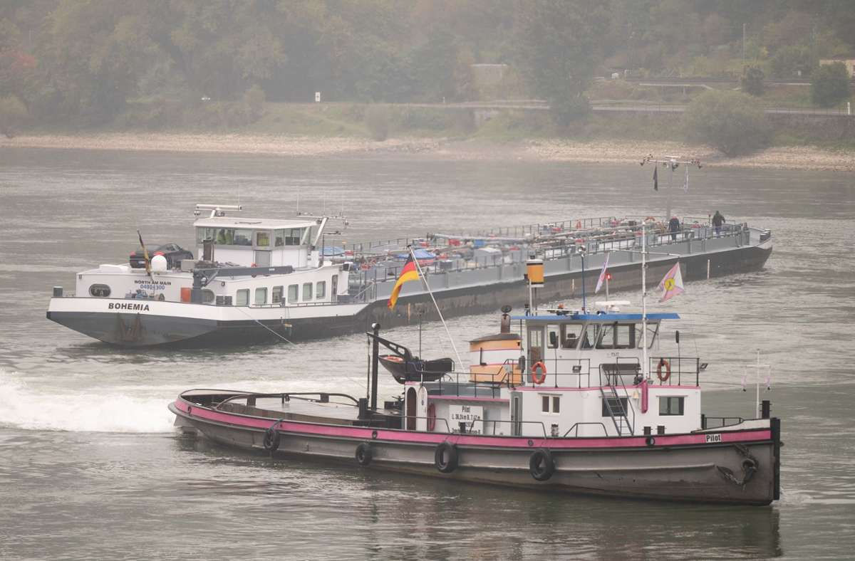 Schlepper ziehen ein auf dem Rhein festgefahrenes Schiff. Es war am Sonntagabend auf den Geisenrücken aufgefahren. Foto: dpa/Sebastian Gollnow
