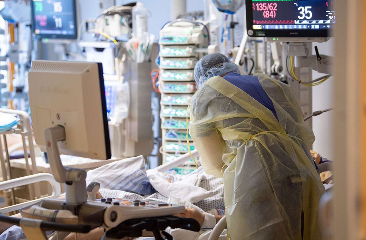 Ein Intensivpfleger arbeitet auf einer Intensivstation des RKH Klinikum Ludwigsburg an einem Covid-19-Patienten. Foto: dpa/Sebastian Gollnow