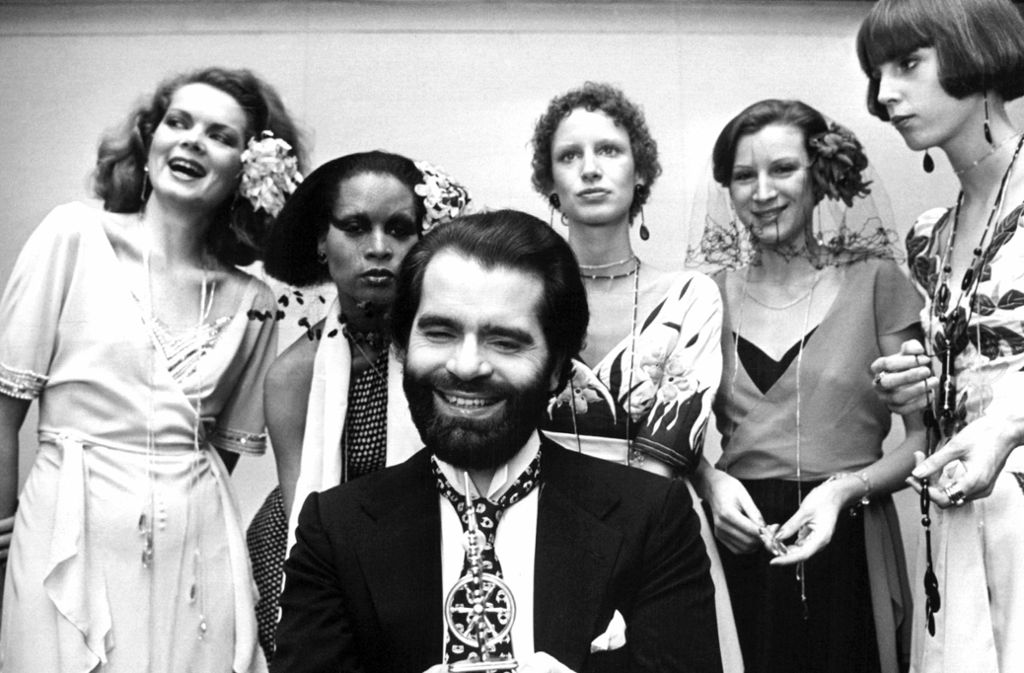 Ein Wollmantel war es, der die große Karriere von Karl Lagerfeld startete. 1955 gewann er den Preis des Internationalen Wollsekretariats. Pierre Balmain, der den Mantel produzierte, engagierte Lagerfeld daraufhin als Assistent. Auf diesem Foto sieht man den Modeschöpfer 1973 umgeben von Models.