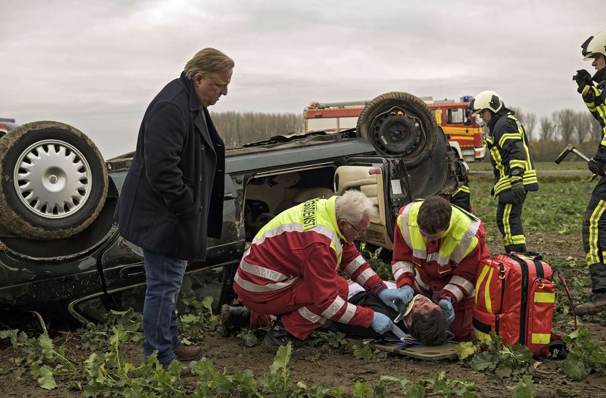 Unfall: Prof. Karl-Friedrich Boerne (Jan Josef Liefers, unten) erleidet einen schweren Autounfall. Kommissar Frank Thiel (Axel Prahl, links) ist mit den Rettungskräften am Unfallort und ist schockiert, als er den verletzten Professor sieht.
