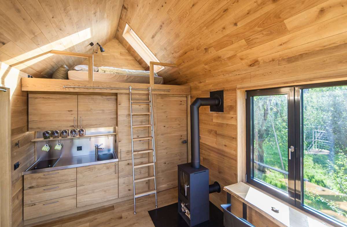 Der Innenraum mit seiner Eichenholzverkleidung bietet Komfort. Über der Pantry und dem Bad befindet sich ein gemütlicher Schlafplatz. Von hier kann man durch ein Dachfenster in die Baumkrone der benachbarten Eiche blicken.