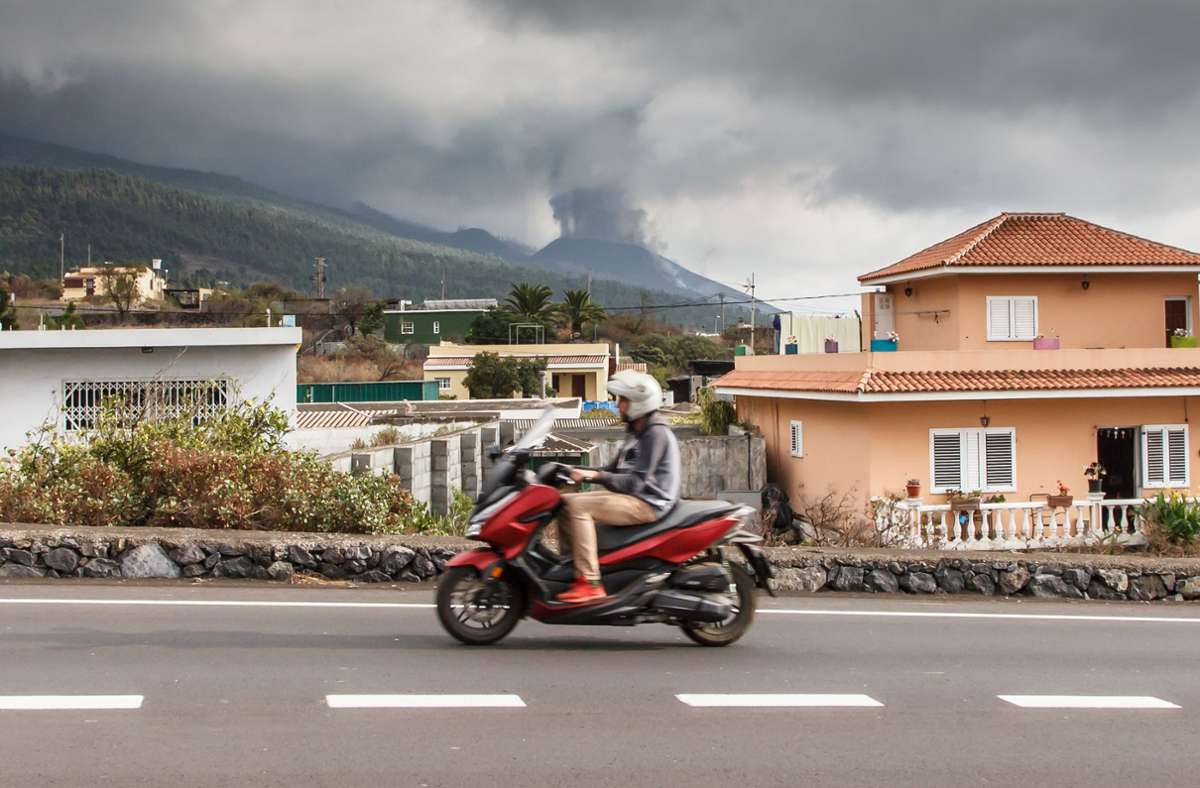 Ein Mann fährt vor dem Hintergrund des ausbrechenden Vulkans Cumbre Vieja auf einem Motorroller (Bild vom 24. September, fünf Tage nach dem Beginn des Ausbruchs).