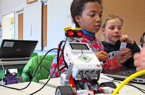 Junge Mädchen programmieren Legoroboter