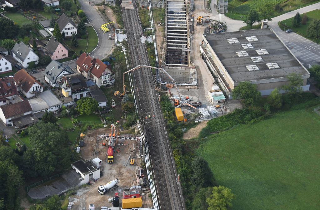 An der Baustelle des Bahntunnels Rastatt sind bei Niederbühl helle Betonflächen (oben) zu sehen und eine Betonpumpe (Mitte). Foto: dpa