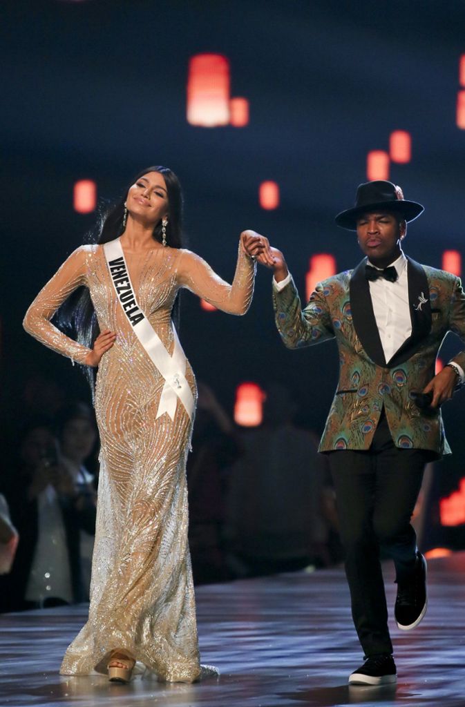 Sänger Ne-Yo geleitet Miss Venezuela, Sthefany Gutierrez, über den Catwalk.